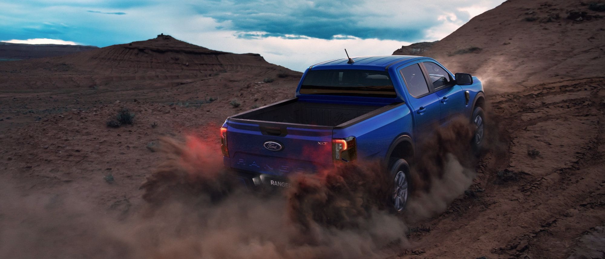 Blue Ford Ranger XLT driving at dusk